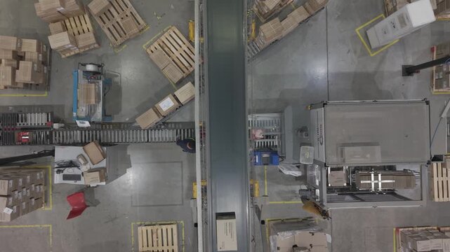 F&aacute;brica en funcionamiento con cinta transportadora y cajas en proceso, obreros trabajando en producci&oacute;n industrial vista cenital, footage industria, trabajo, industrializaci&oacute;n, desarrollo