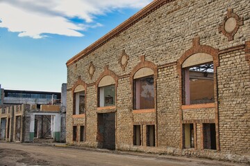 Obraz premium Old Abandoned Factory Building with Limestone and Brick Facade