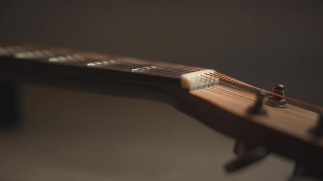 Close up acoustic guitar headstock with tuning pegs