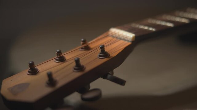 Guitar headstock and neck in warm shallow focus