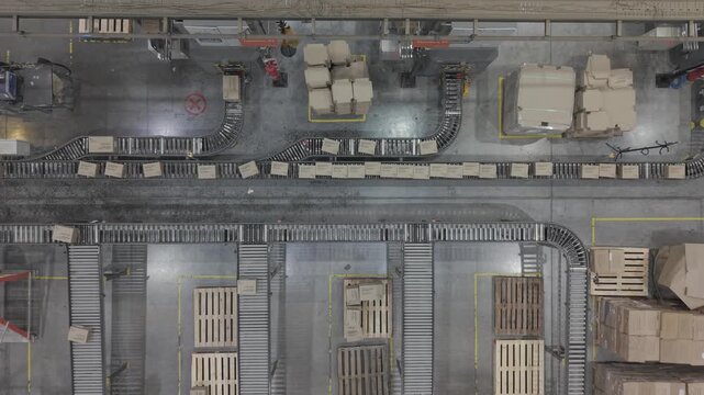 F&aacute;brica en funcionamiento con cinta transportadora y cajas en proceso, obreros trabajando en producci&oacute;n industrial vista cenital, footage industria, trabajo, industrializaci&oacute;n, desarrollo