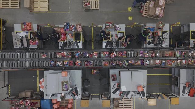 F&aacute;brica en funcionamiento con cinta transportadora y cajas en proceso, obreros trabajando en producci&oacute;n industrial vista cenital, footage industria, trabajo, industrializaci&oacute;n, desarrollo
