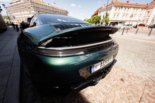 Green Porsche 911 Targa 4 GTS rear view parked on a cobblestone street in Vilnius Lithuania city center