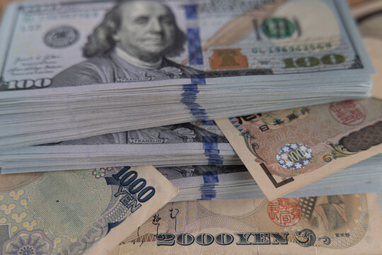 US dollar banknotes stack with Japanese yen bills close up