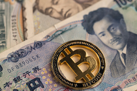 Gold Bitcoin coin on US dollar and Japanese yen banknotes