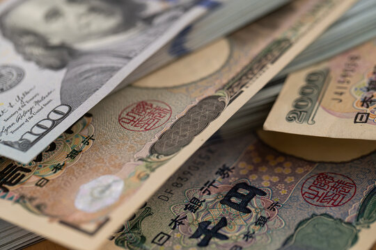 US hundred dollar bills and Japanese yen banknotes background