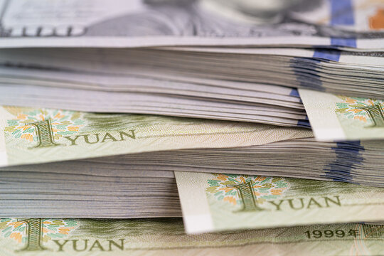 US dollar banknotes stack with Chinese yuan bills close up
