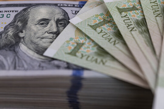 US dollar banknotes stack with Chinese yuan bills close up