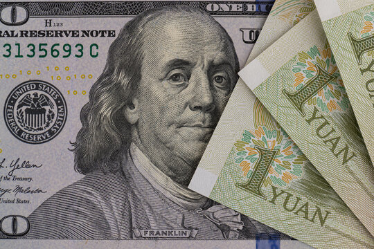 US dollar banknotes stack with Chinese yuan bills close up