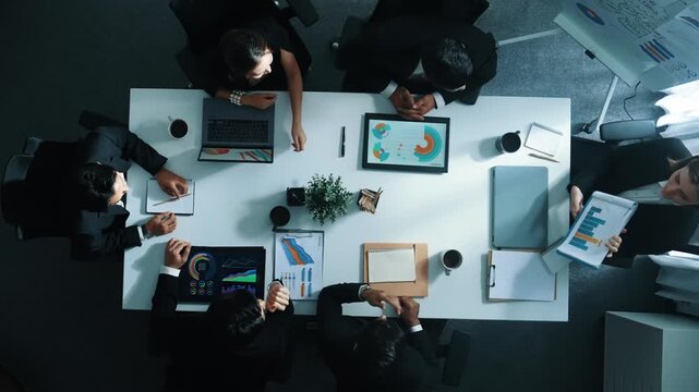 Top down aerial view of diverse business team listening manager present growth sales while giving a high five to encourage or motivate team. Group of people celebrate successful project. Directorate.