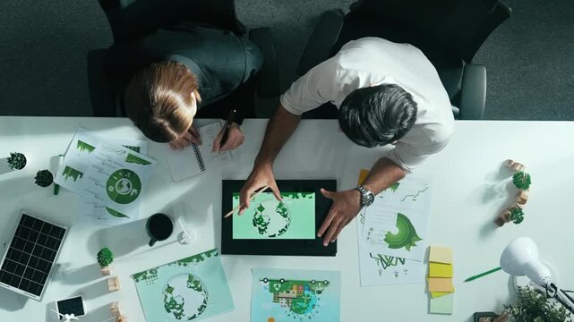 Top down view of business man presenting sustainable idea to manager by using tablet display ESG environmental social governance. Manager working together planning to use clean energy. Alimentation.