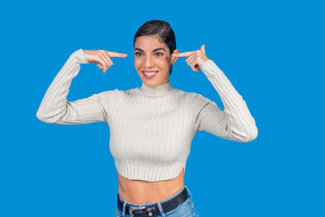 Naklejka premium Woman smiling pointing to temples showing intelligence