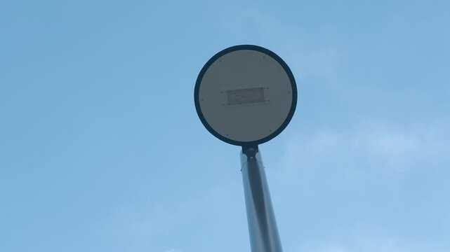 Circular street sign on pole against blue sky