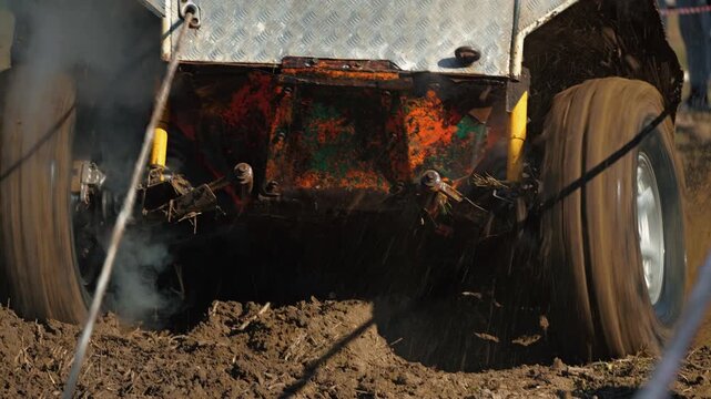 A close-up of a 4x4 SUV competing in an off-road competition. The wheels spin, splashing mud across the muddy track. The concept of extreme motorsports for adventure and challenge