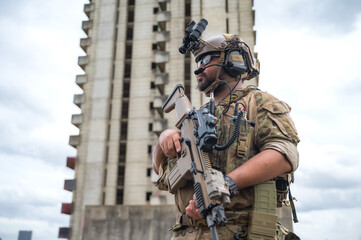 Obraz premium Armed military squad in full gear holding rifle patrolling an abandoned building 