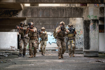 Fototapeta premium Special armed military squad team in full gear patrolling an abandoned building during hostage crisis