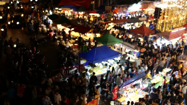 Crowd of Asians at night market. Phra Samut Chedi Temple fair. It is one of the biggest temple fairs in Thailand. People can easily get there by BTS city train from Bangkok. 
