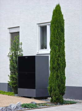 efficient modern heat pump installed beside traditional house enhancing sustainable heating with greenery