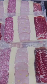 Gourmet selection of salami, pistachio mortadella, cured pork shoulder and sliced ​​cheese packaged in a supermarket gondola