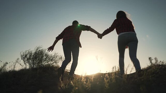 Couple running holding hands at sunset silhouette outdoor adventure. Two people run together at golden hour. Romantic partners exercise outdoors. Active couple enjoys sunset run holding hands.