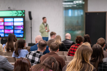 Obraz premium Attentive audience listening to presenter at business conference, modern meeting room, networking and learning atmosphere, professional event, presentation and public speaking.