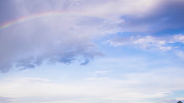 Multi-colored rainbow flaunts on top of the Rhodope Mountains above intermountain valley with the village of Smolyan