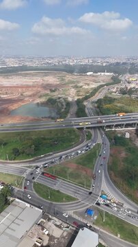 Vista superior do tr&aacute;fego em Itaquaquecetuba, com carros em fila, rodovia, avenida marginal e viaduto ligando bairros da cidade na regi&atilde;o do Alto Tiet&ecirc; paulista.
