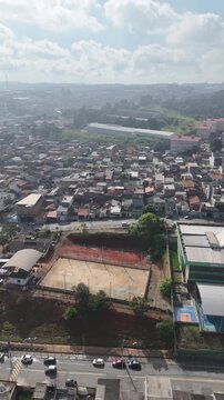 Vista superior de Itaquaquecetuba, SP, com corredor vi&aacute;rio, galp&otilde;es, bairros residenciais e intenso fluxo de ve&iacute;culos compondo a paisagem urbana do Alto Tiet&ecirc;.