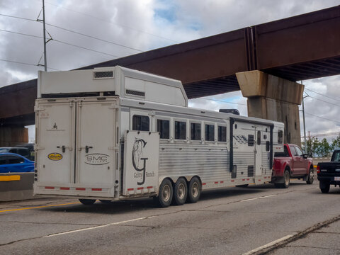 Calgary, Alberta, Canada. June 17, 2026. Large SMC horse trailer branded Gritty Ranch towed by a pickup truck under an overpass.