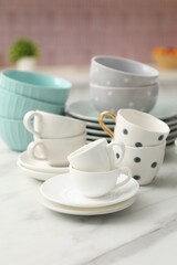 Fototapeta premium Different clean dishware on white table in kitchen, closeup