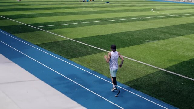 Paraathletic runner with bionic prosthetic leg trains at stadium