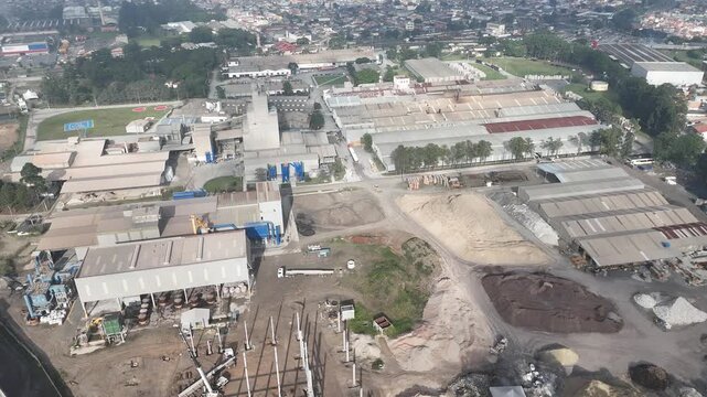 Vista a&eacute;rea de ind&uacute;stria de materiais refrat&aacute;rios e isolantes t&eacute;rmicos, com galp&otilde;es, p&aacute;tios, &aacute;reas de produ&ccedil;&atilde;o e estoque em ambiente industrial urbano no Brasil.