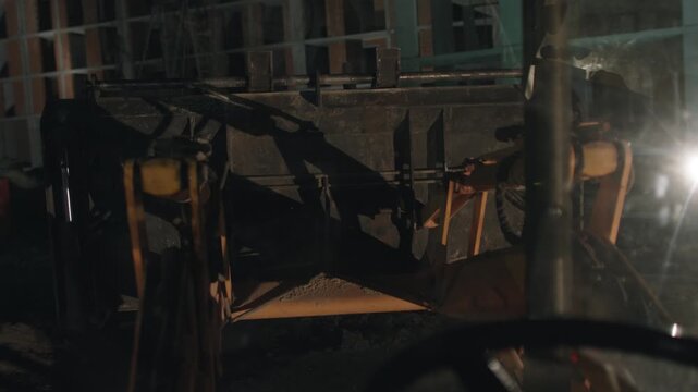 Rusted machinery in dim scrapyard with metal beams, hoses, oil stains and broken glass, eerie industrial decay and low light