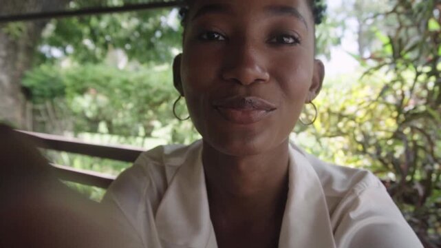 African woman taking selfie with smartphone outdoors