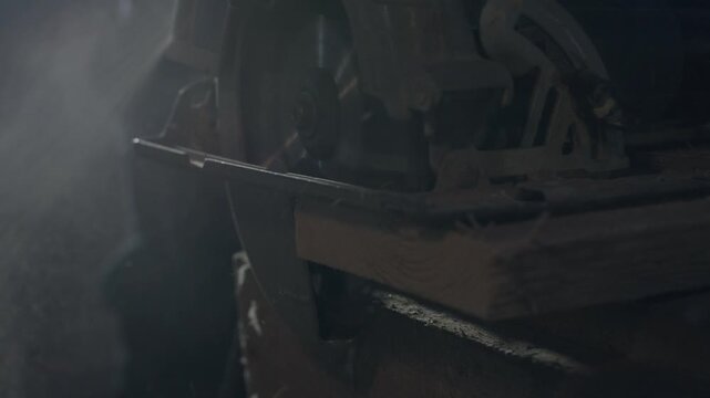 Dim workshop closeup rifle barrel resting on dusty wood workbench antique gunsmith tools and metal parts emerge through soft haze,