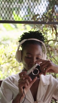 Young african american woman taking a picture with a retro camera