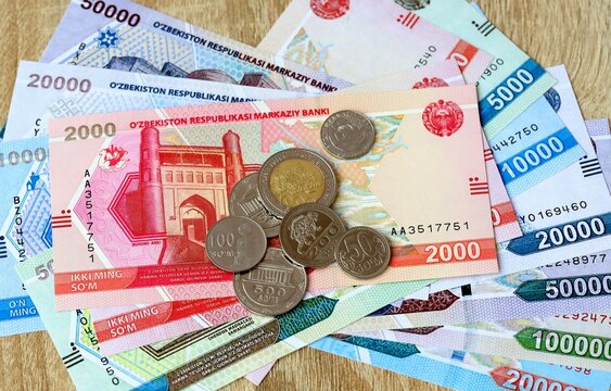 Uzbekistani som money bills and coins on table. Uzbekistan cash of UZS currency close up