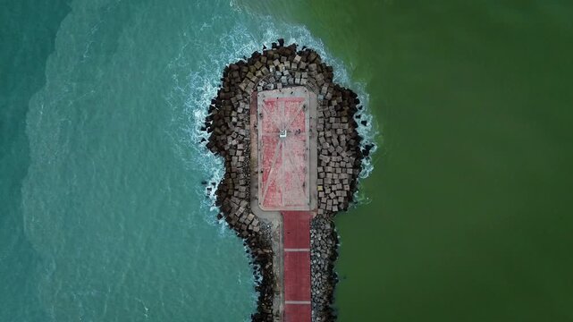 Aerial zenith drone shot of Miramar Beach breakwater in Tamaulipas, where the Panuco River meets the Gulf of Mexico, creating a striking natural color division between fresh and salt water