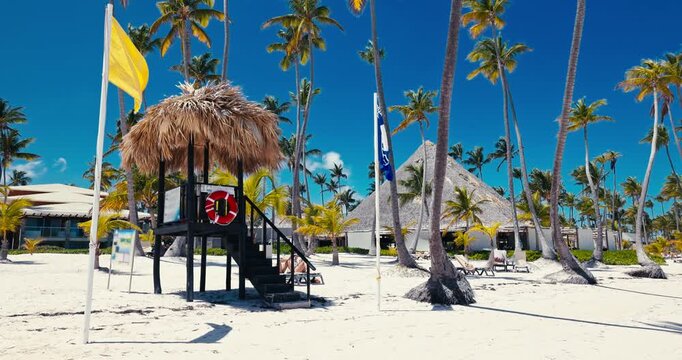 Exotic white sand beach in Punta Cana, Dominican Republic and wooden lifeguard tower with a straw roof and lifebuoy ring