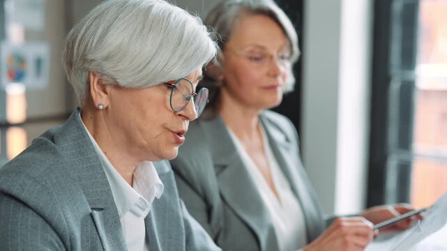 Elderly ladies in board of directors in modern international financial company. Mature women working in office, making decisions and solving problems, strategic thinking and business development
