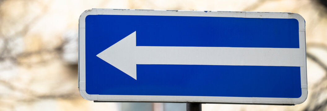 Directional arrow sign indicating road guidance, symbolizing navigation, travel direction, orientation, and wayfinding in urban or rural transportation environments for drivers and pedestrians.