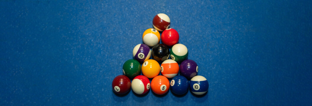 Colorful billiard balls arranged on a pool table, representing cue sport recreation, precision gameplay, entertainment, and competitive leisure activity in an indoor setting.
