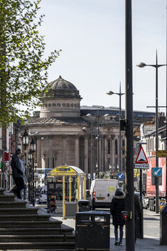 Liverpool, United Kingdom - 06 May 2026: View of the historic neoclassical architecture of the Picton Reading Room and William Brown Library with a bus stop and people on a city street.