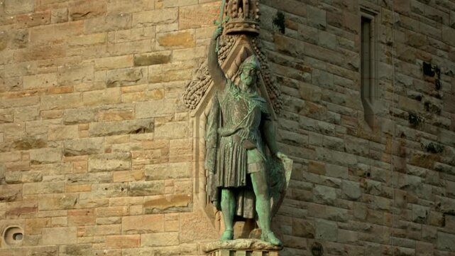Bronze statue of William Wallace holding a sword aloft on the National Wallace Monument in Stirling