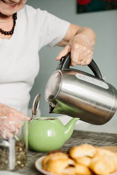 Senior woman preparing hot tea at home