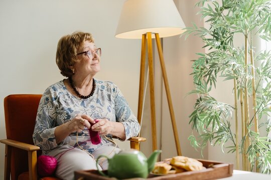 Senior woman knitting, enjoying relaxing home hobby