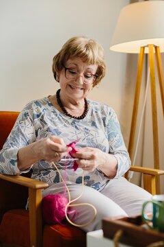 Senior woman enjoying knitting hobby at home
