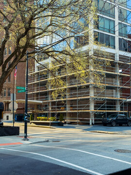 Construction work is taking place on a building located at the corner of Astor and Goethe in a city setting during daylight hours