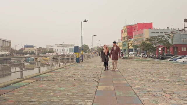 Romantic young couple walking hand in hand in caminito