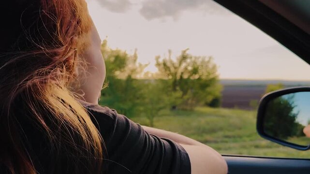 young woman girl driving car looking out window sunset, smile face woman girl, wind hair woman girl looking window car ray sun, adventure carefree brunette cinematic nature, trip road outdoors, happy